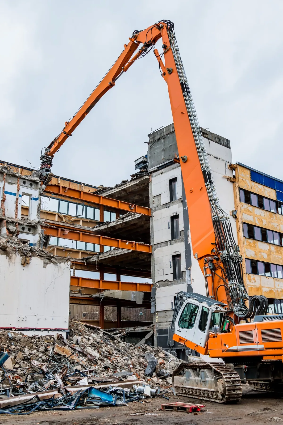 High-reach excavator demolishing a multi-storey commercial building