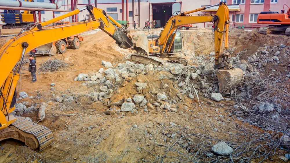 Excavator demolishing an industrial building